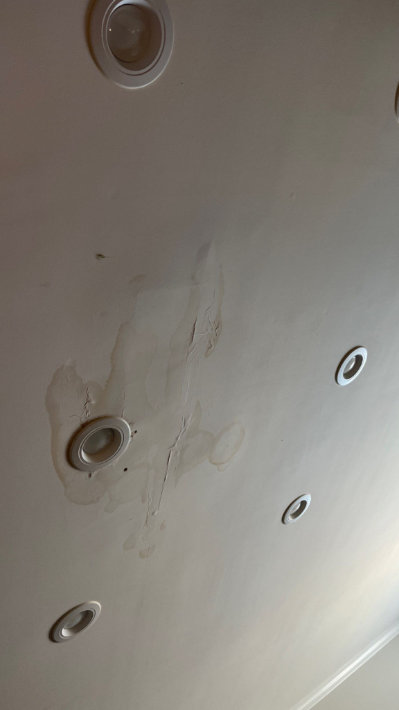 brown and bubbly ceiling around lights showing water damage in the ceiling - water restoration services - Independent Restoration Services - West Tennessee